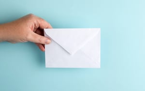 Image of a hand holding an envelope in a blog post about Microsoft Teams