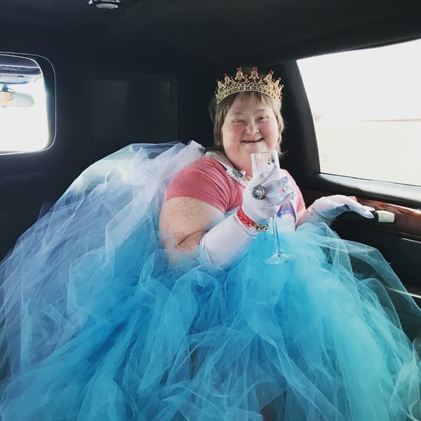 Princess Sarah wearing a tutu and crown in a limo