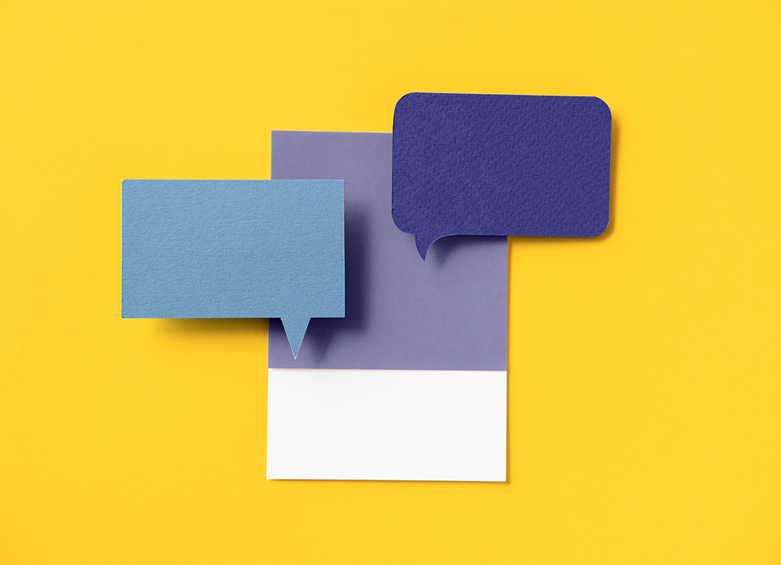 Pieces of blue and purple paper cut into the shape of a chat bubble