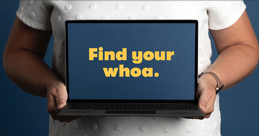 A woman holding a laptop that says, "Find your whoa."