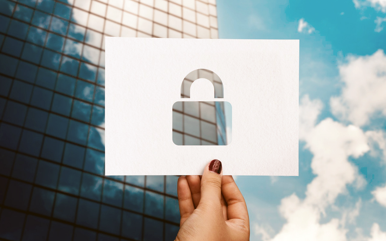 A woman's hand holding an image of a lock