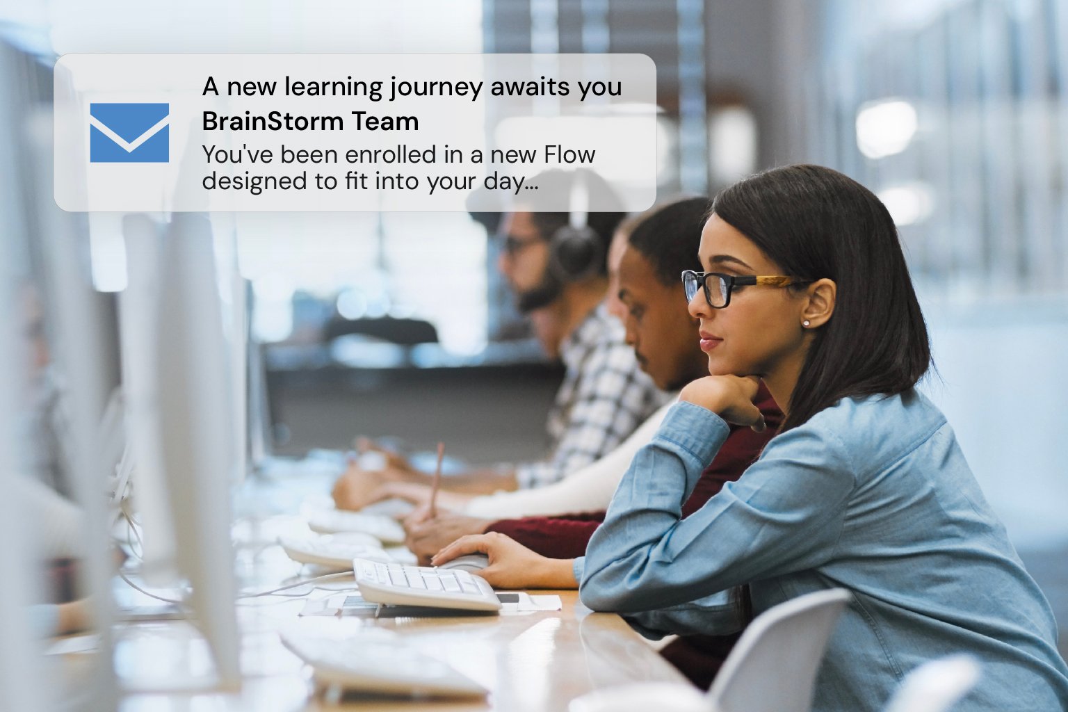 A woman working at a computer receives an email for new training from BrainStorm